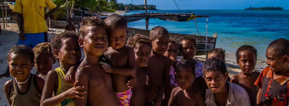 Local kids smiling and posing on a beach in the south pacific. 