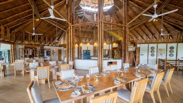 Inside the open-air dining room, with thatch-roof & wood tables at La Selva Amazon EcoLodge overlooking Lake Garzacocha.