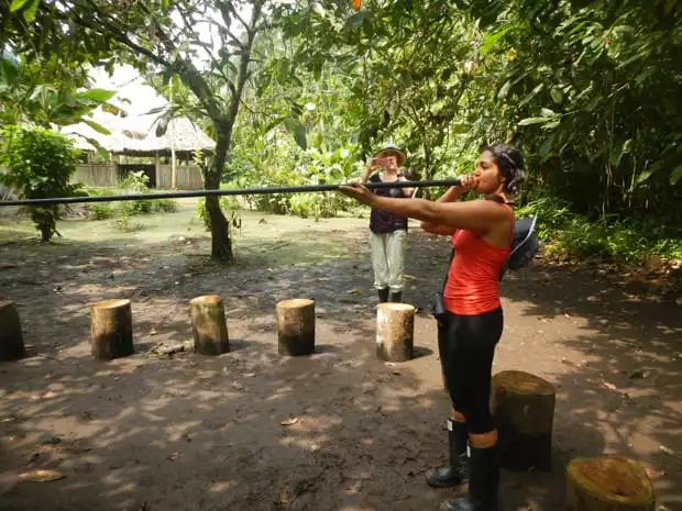 Amazon traveler blowing into a blow gun at La Selva Lodge.