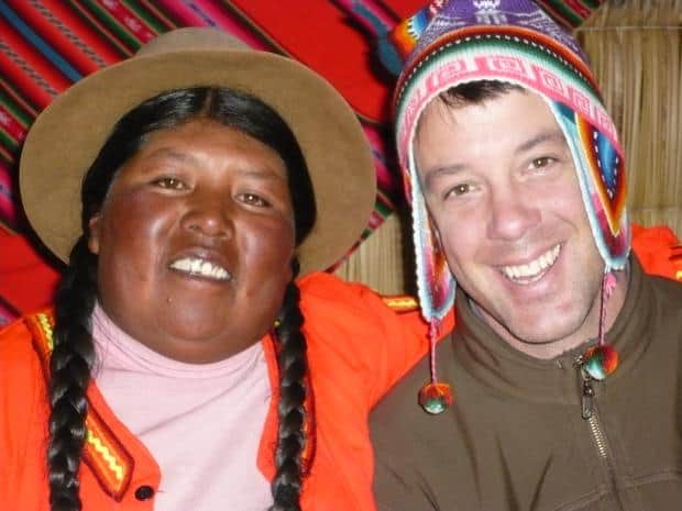 Traveler wearing a woven colorful beanie posing with a Peruvian woman.