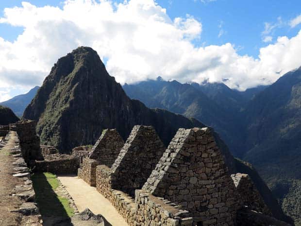 Triangular shaped stonework from Machu Picchu with large mountain ranges.