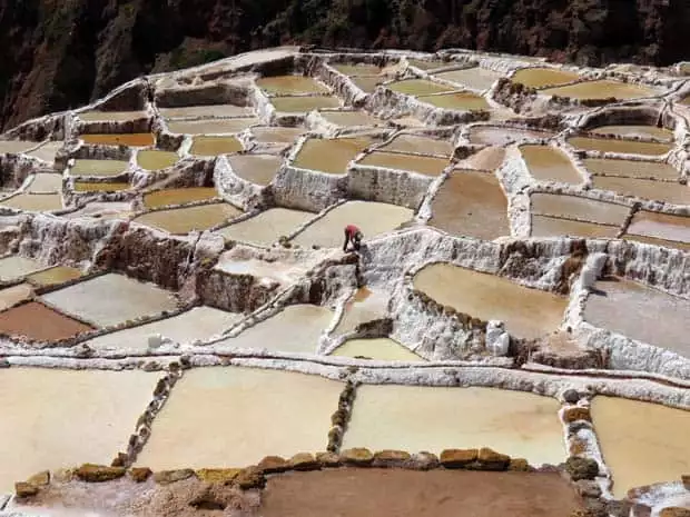 View of terraced land surfaces with a single man working the site.