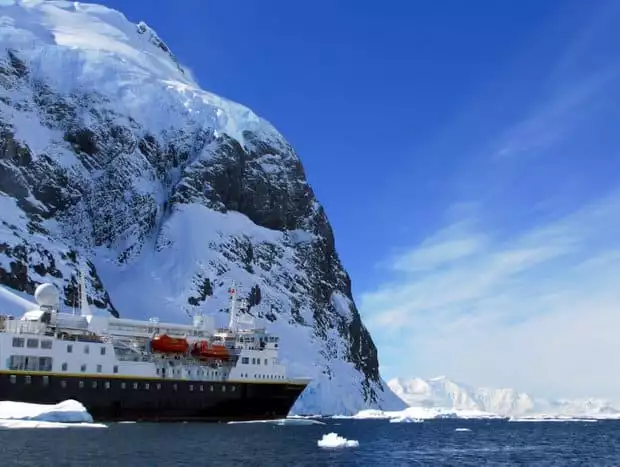 Small expedition cruise ship near land in Antarctica. 
