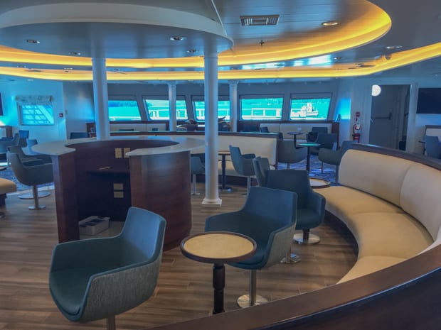 Interior lounge of National Geographic Quest with booth seating and podium 