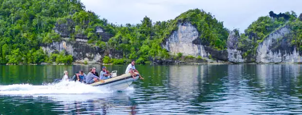 Guests taking a skiff off a small ship cruise to explore islands in Indonesia. 