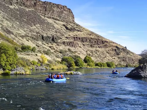 Guests on a river cruise tour floating in rafts on the Deschutes River