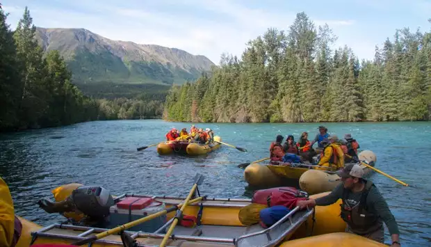 A group of people in rafts floating down the Kenai River. 