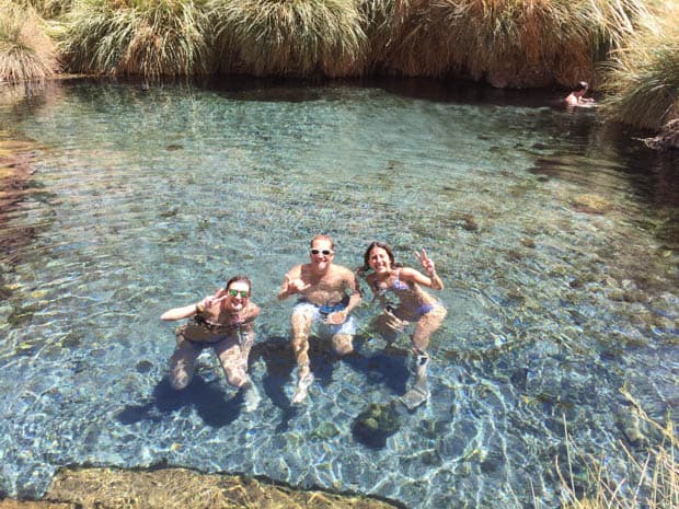 Group of Chile travelers swimming in a clear water natural pool.