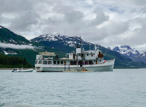 The small ship cruise Sea Wolf anchored off the coast in Alaska with kayaks.