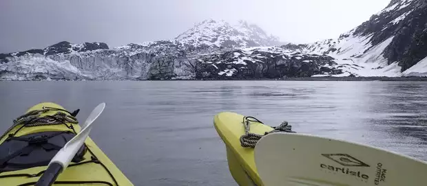 Two kayaks resting in the ocean looking at tidewater glaciers in Alaska.
