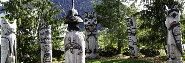 Tlingit totem poles set in a circle among the Alaskan forest.