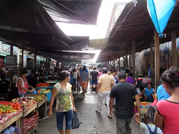 A busy market place in Peru filled with vendors and customers. 