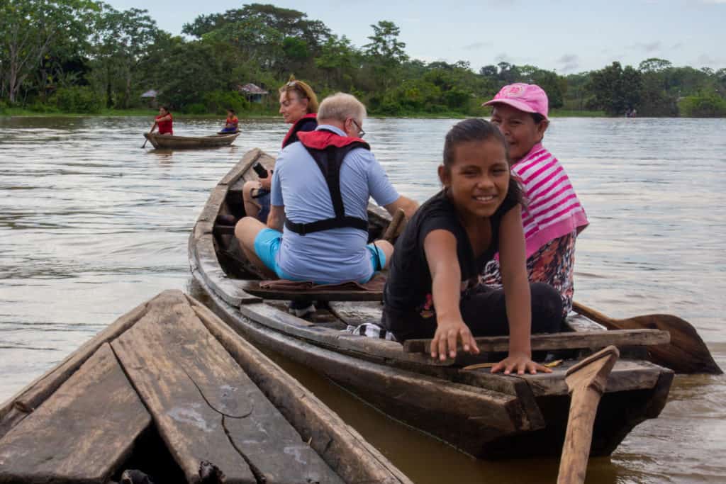 Amazonian people and travelers aboard a dugout canoe in the Amazon.