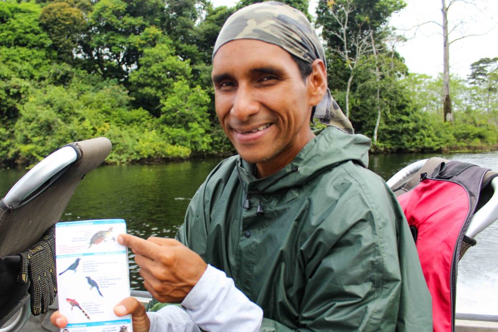 An Aria guide smiling and showing the group pictures of birds on a card.