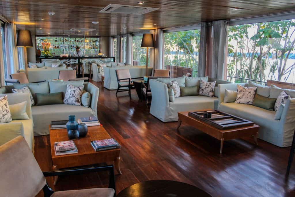 The lounge area of the Aria with couches, tables and large windows.