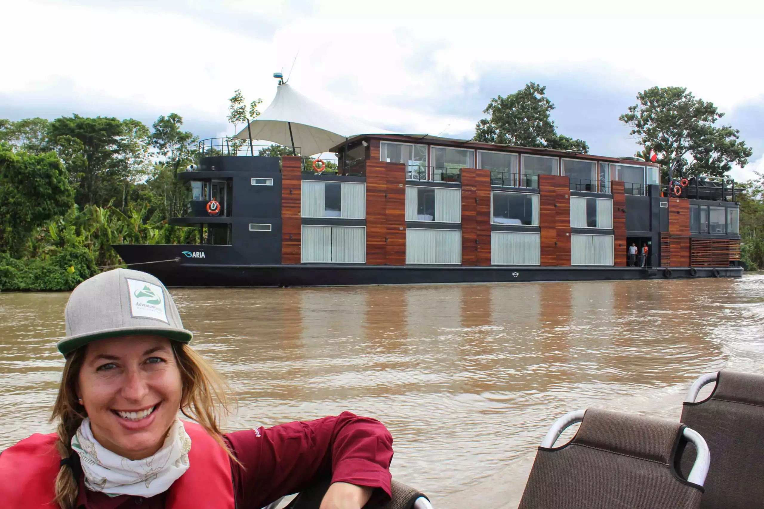Women in adventure gear, posing in front of a small river cruise in the amazon