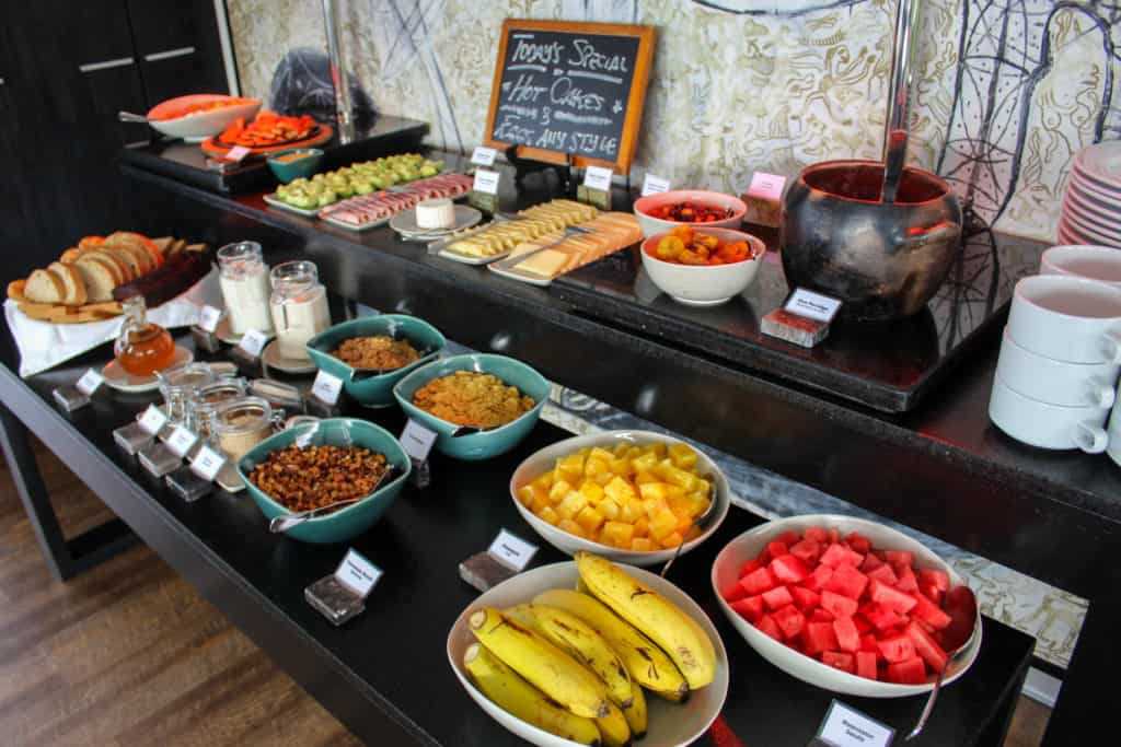 A breakfast spread aboard the Aria with fruits, bread, cheese, cereal and rice pudding.