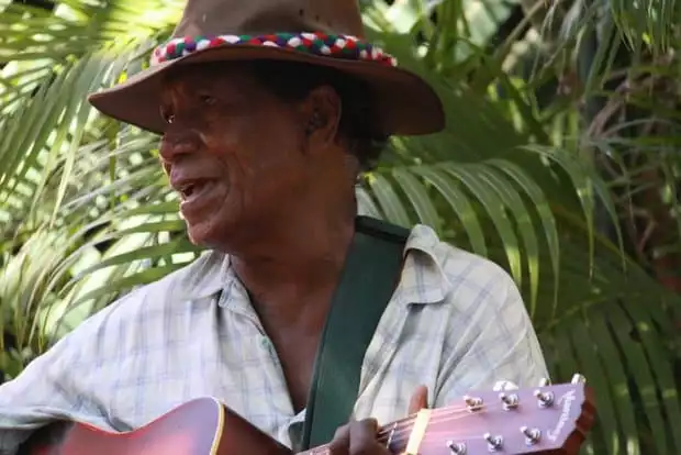 A man with a hat playing a guitar in Australia