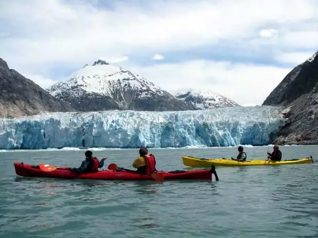 A group of people kayaking near a glacier in Alaska. 