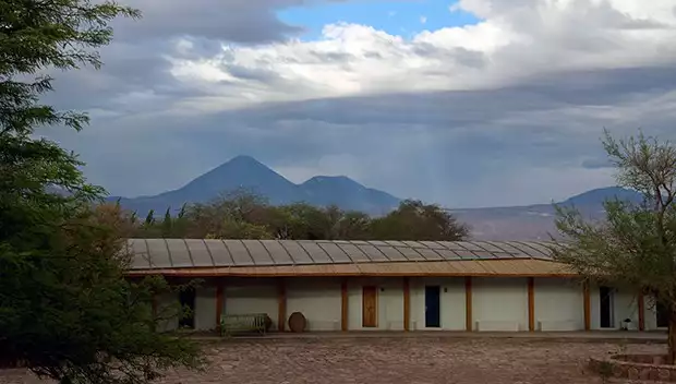An images of the Explora Atacama lodge with a big volcano in the background.