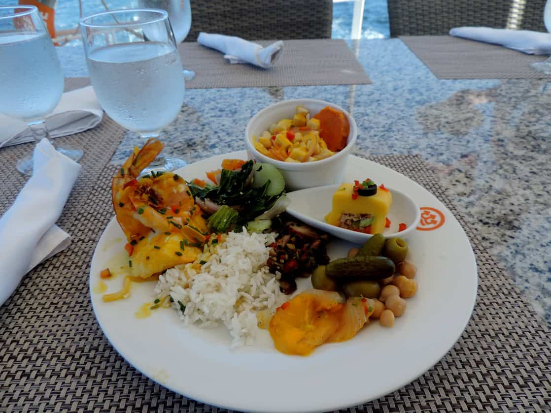 Plate seafood, fruit and vegetables on a table aboard a small ship cruise.