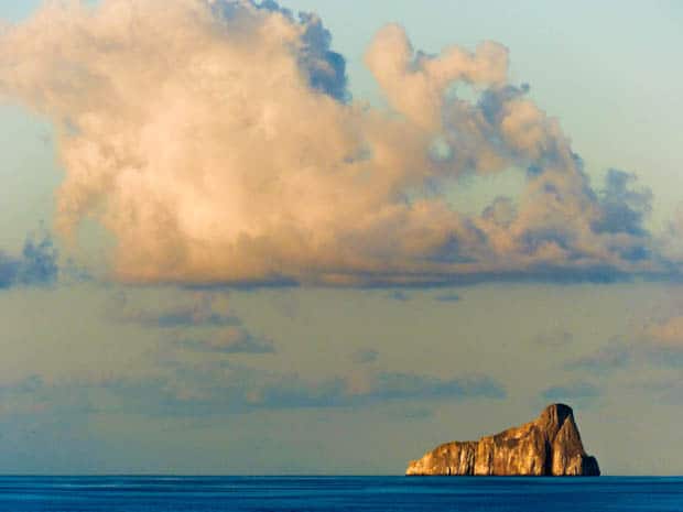 Large rock formation sticking out in the ocean.