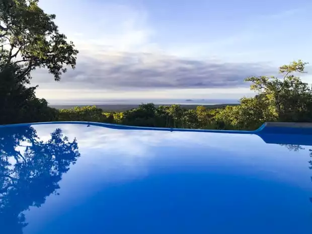 View of a blue pool overlooking scenic landscape on a Galapagos land tour.