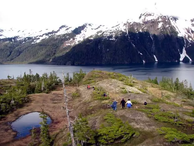 People hiking down a ridge in Alaska. 