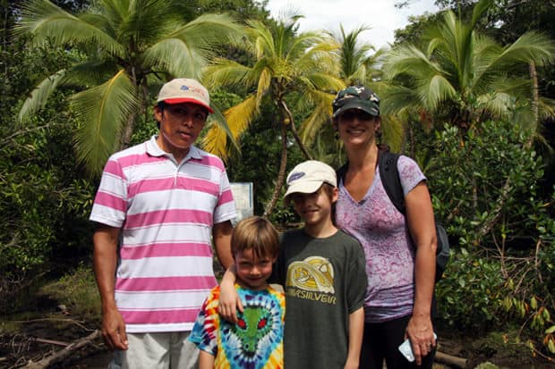 Family on a small ship cruise excursion exploring the rainforest with their guide. 