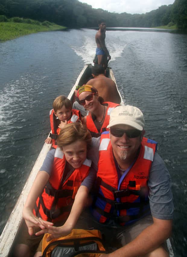 Family from a small ship cruise on an excursion to a remote local village in the jungle.  