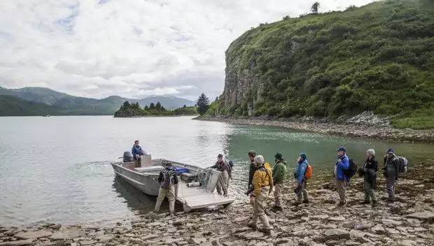 Guests from small ship cruise get on a skiff excursion from the shore in Alaska. 