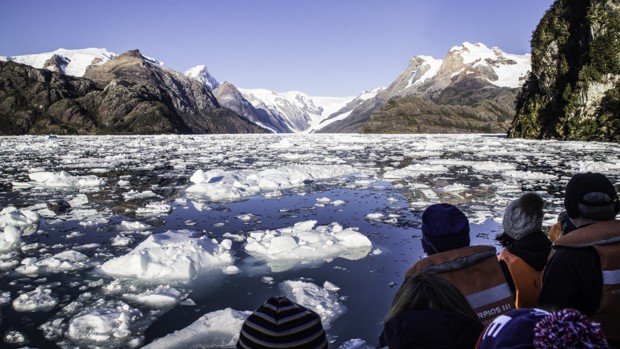 A group of people looking out at floating ice in Patagonia. 