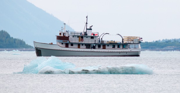 Iceberg floating in front of the small ship cruise Sea Wolf in Alaska. 