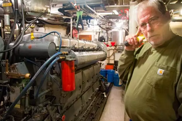 Engine room and crew member aboard the small ship Sea Wolf. 