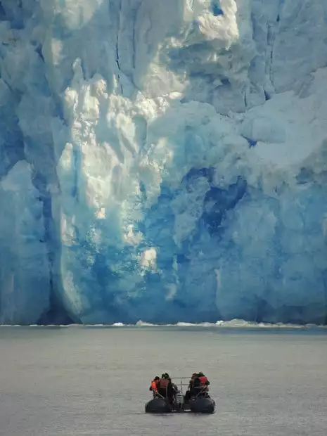 Guests on a skiff excursion from their small ship cruise in Alaska getting up close to a glacier. 
