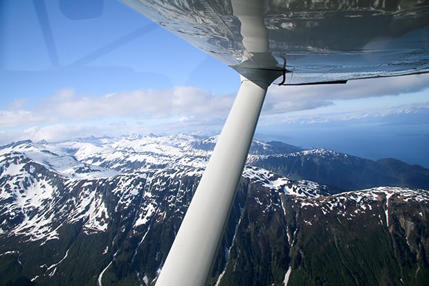 View of snowy mountains and a waterway from a seaplane on the flight to Gustavas Alaska. 