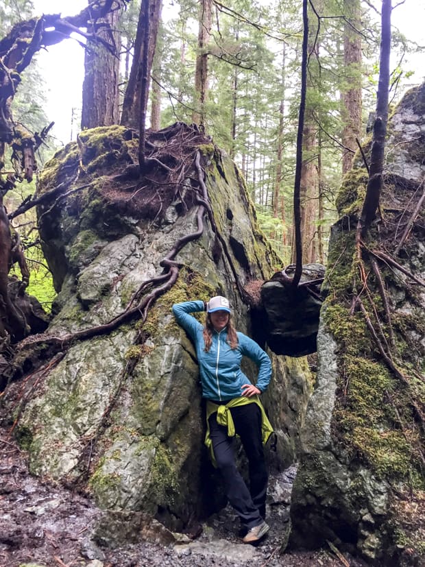 Happy guest posing with boulders on a hike in Alaska. 