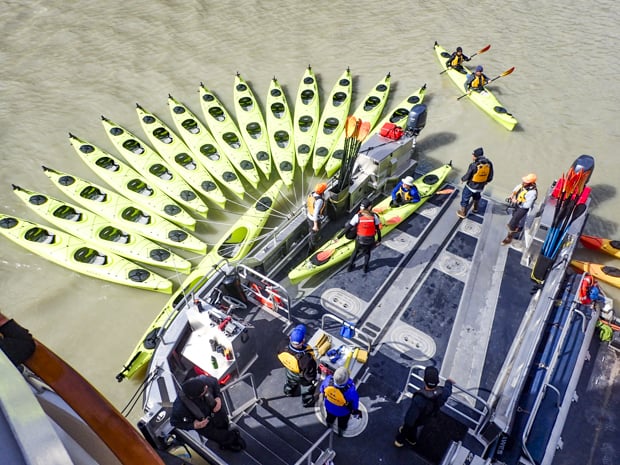 Cluster of Kayaks empty and in the water ready for guests to get in straight from their small ship cruise in Alaska. 