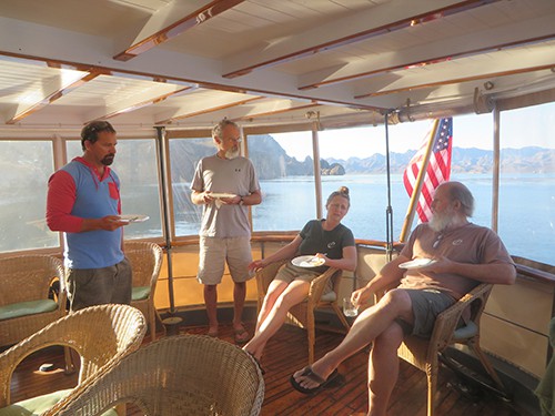 baja small ship cruise passengers relax on a covered deck of the westward 