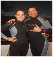 The two travelers in wetsuits at night excited for the night dive
