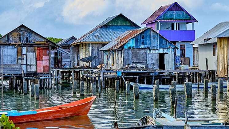 Dilapidated village painted in bright colors and standing on wooden stilts above the water in Indonesia.