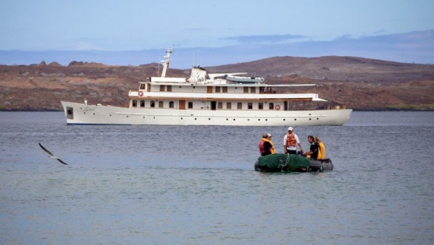 Small ship Galapagos cruise aboard historic Grace with zodiac sailing toward the viewer