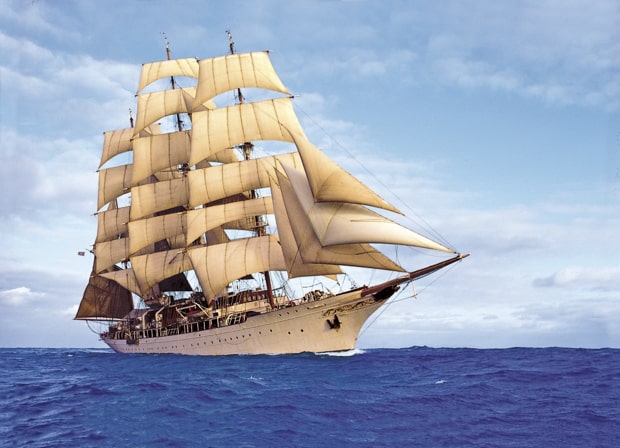 White sails fully up on the historic and luxurious Sea Cloud on a small ship cruise in the Mediterranean. 