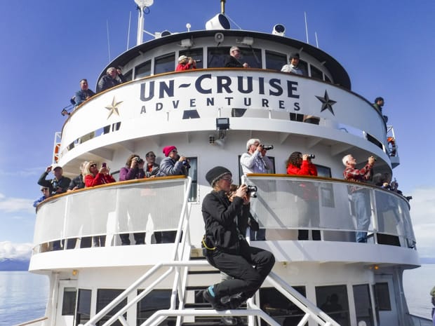 Guests spotting wildlife from the bow of the small ship S.S. Legacy in Alaska.