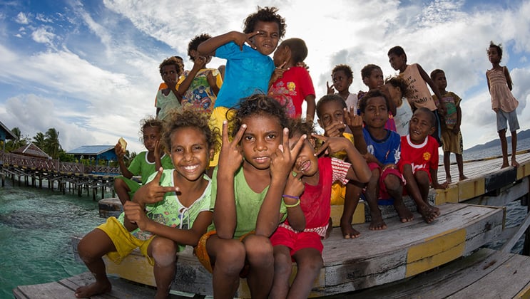 West Papuan children in Arborek Village pose for a picture on the dock during the Aqua Blu Raja Ampat Indonesia culture cruise.