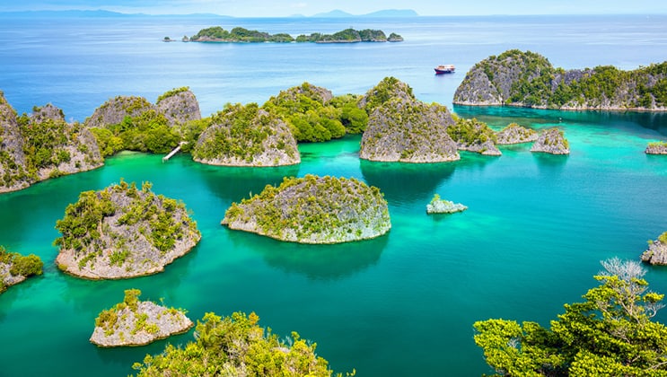 Aerial view of limestone karst gumdrop islands in emerald waters as seen on the Aqua Blu Raja Ampat Indonesia luxury cruise.