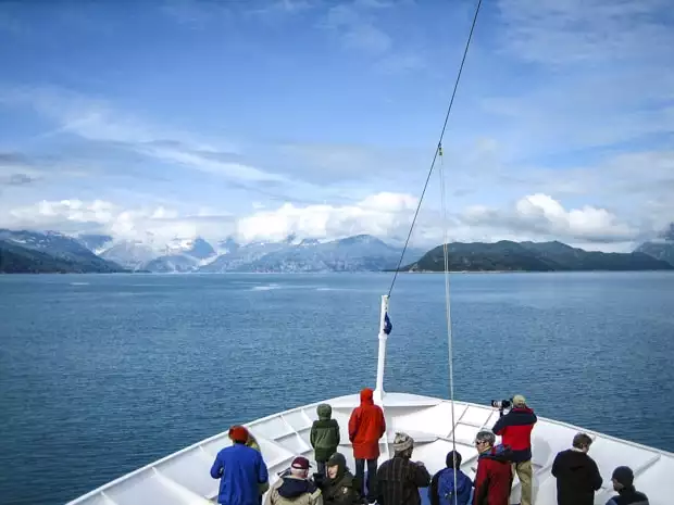 Passengers on bow of small ship cruising the Inside Passage of Alaska. 