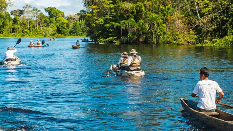 Two people kayaking on river in the Peruvian Amazon