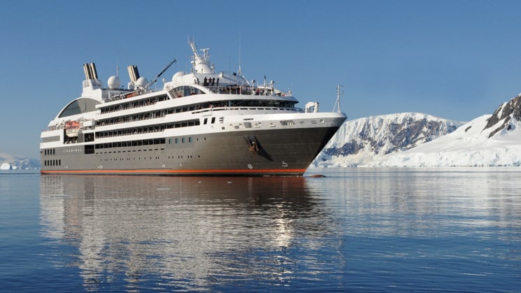Exterior of expedition ship L'Austral with 6 passenger decks & gray hull, cruising in Antarctica.