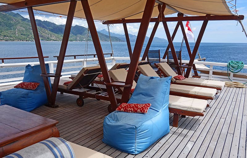 louge area outside on the sterns of the indonesia small ship ombak putih, traditional Indonesian pillow chairs are also set about the deck